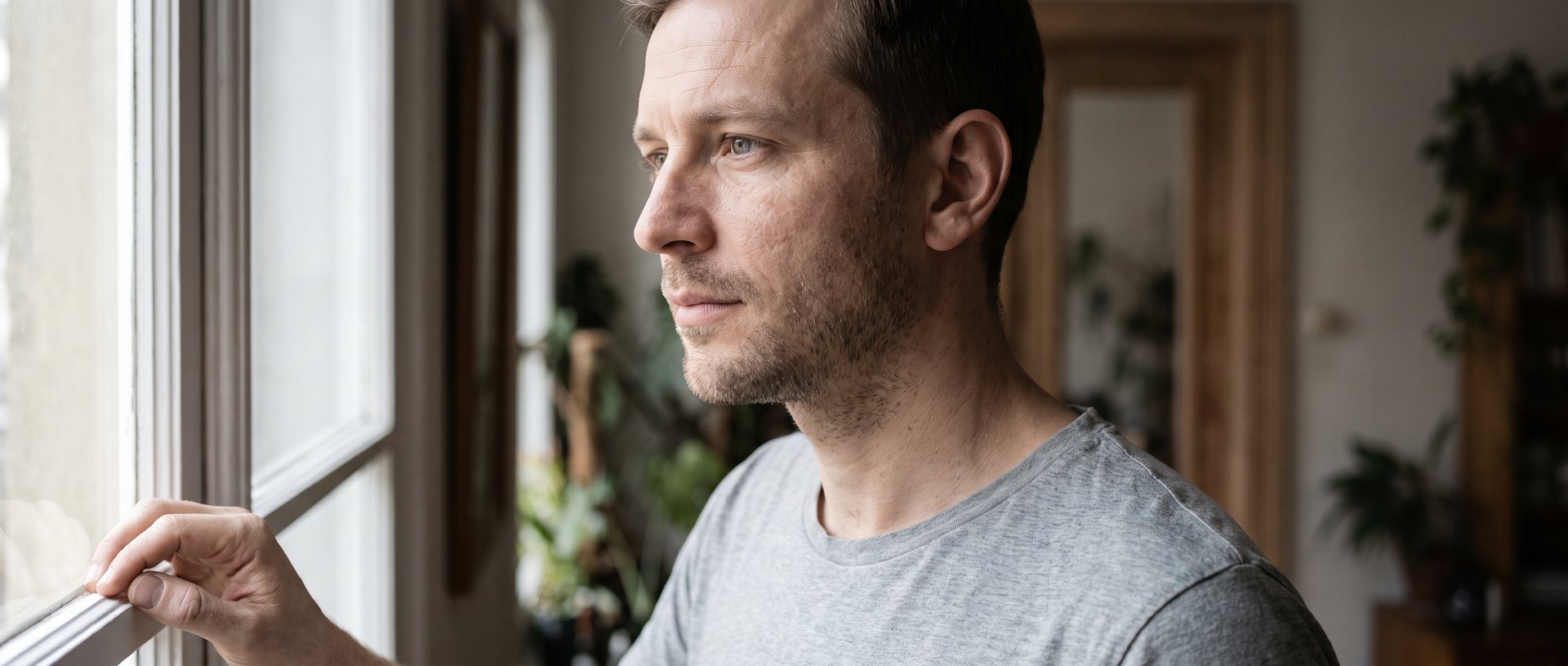 AI-generated illustration of a man in his thirties looking out of a window